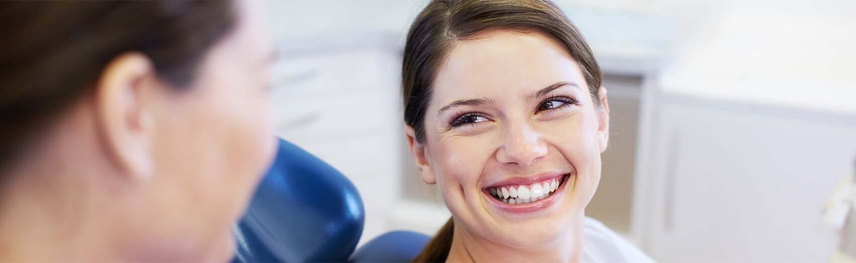 Woman smiling while sitting in dental exam chair