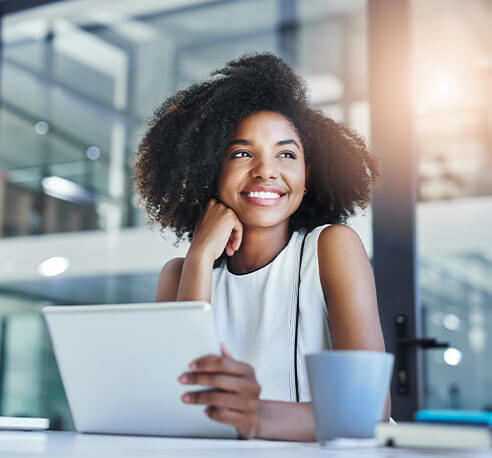 smiling woman sitting in front of a laptop