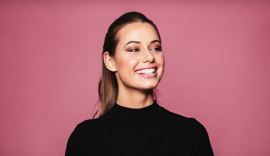 Brunette woman in a black blouse smiles brightly