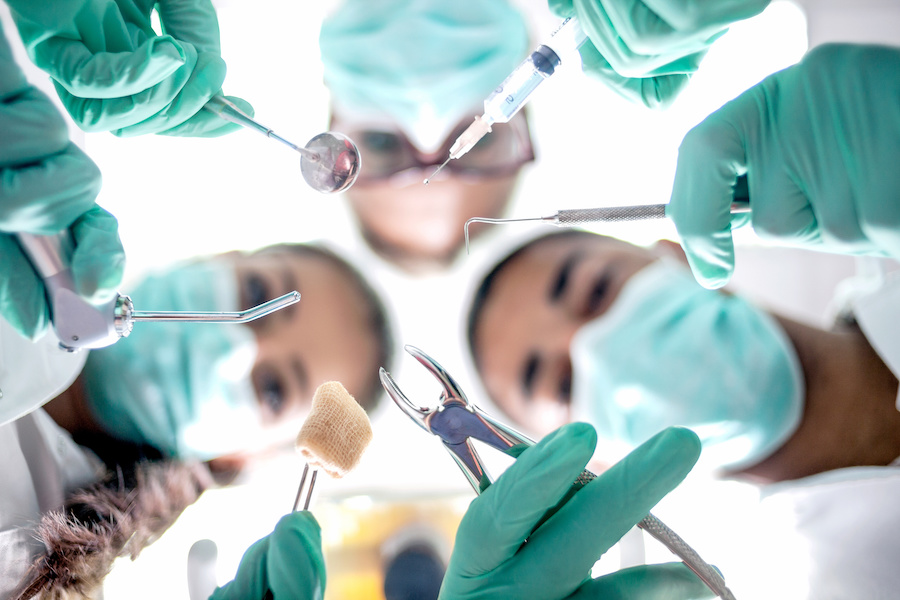 Dental team working during oral surgery, extraction, dental procedure