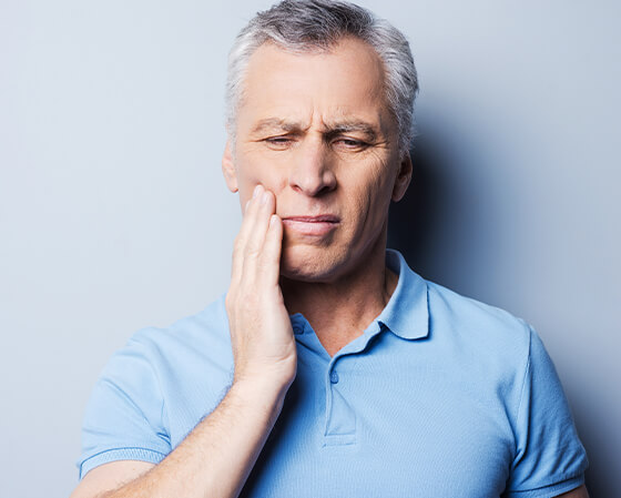 man holding his jaw in pain